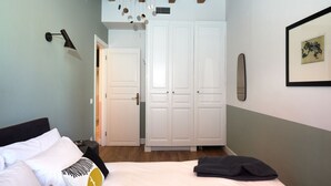 Una camera da letto con un letto, un armadio bianco e un quadro appeso al muro.