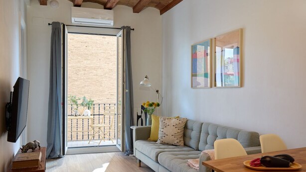 Ein modernes Wohnzimmer mit einer Couch, einem Esstisch und einem Balkon mit Blick.