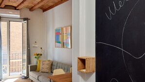 Ein gemütliches Wohnzimmer mit einer Couch, einem Holztisch und einer Tafelwand mit dem Schriftzug 'welcome'.