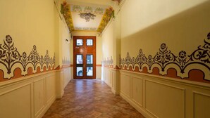A hallway with ornate wall decorations and a wooden door at the end.