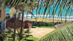 Un resort con piscina, palmeras y vista al océano.