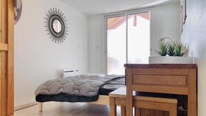 A bedroom with a bed, a wooden desk, a mirror, and a window with a view of a red roof. - #CP - House - Magnificent view - garden 💓 (Lumbin)