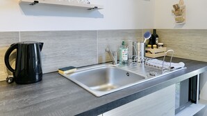 A modern kitchen with a stainless steel sink, a kettle, and various kitchen items on the counter. - #CP - House - Magnificent view - garden 💓 (Lumbin)