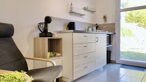 A modern kitchen with a built-in coffee machine, a microwave, and a sink. There is a window providing a view of the outdoors. - #CP - House - Magnificent view - garden 💓 (Lumbin)