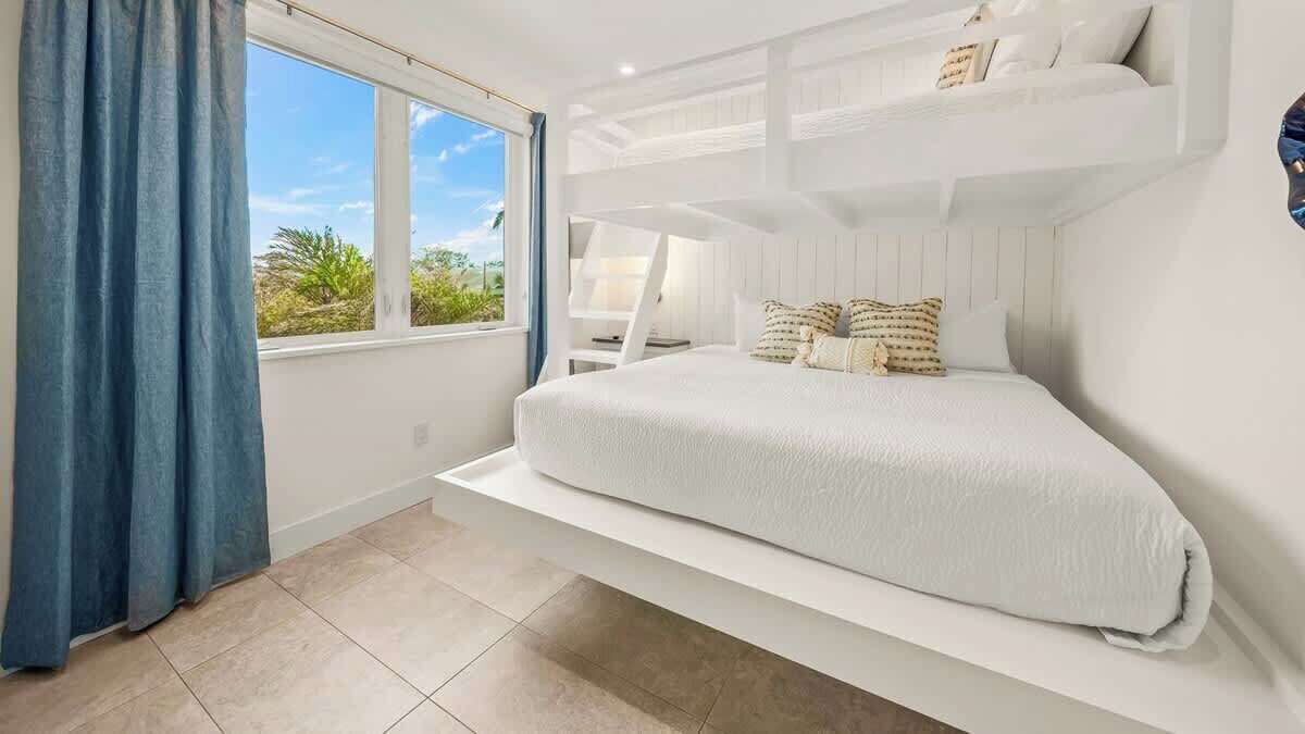 Une chambre à coucher avec un lit, une fenêtre et une vue sur la verdure.