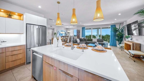 A modern kitchen with a large island, stainless steel appliances, and pendant lighting. - Steps to Beach/Gulf Views/Pool Volleyball/Slide (Siesta Key)