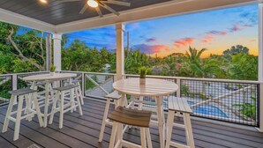 A covered outdoor area with a wooden deck, a ceiling fan, and a view of a swimming pool and greenery. - Resort Pool w/Slide - Walk to Beach & Village (Sarasota)