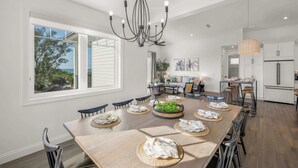 A spacious kitchen with a large island, white cabinetry, and a view of the outdoors. - Steps to Beach/Pool w/Slide and Chipping Green (Sarasota)