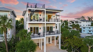 A multi-story residential building with balconies, large windows, and a driveway. - Steps to Beach/Pool w/Slide and Chipping Green (Sarasota)