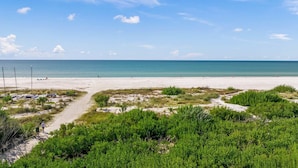 A beach with a clear sky, sandy shore, and green vegetation. - Steps to Beach/Pool w/Slide and Chipping Green (Sarasota)