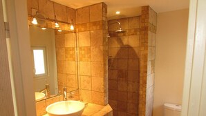 Une salle de bain avec un grand lavabo, une douche et des toilettes.