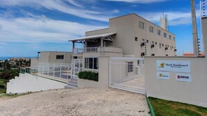 Un edificio moderno con entrada protegida por un portón, un área exterior techada y señalización para Beach Townhouses I.