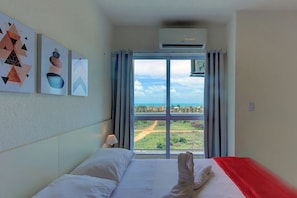 A hotel room with a bed, a window with curtains, and artwork on the wall. - Casa em Porto das Dunas por Carpediem (Aquiraz)