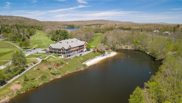 Eine Lodge mit einem großen Gebäude, einem Golfplatz und einem Fluss.