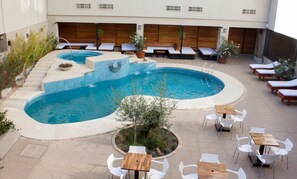 A swimming pool with multiple seating areas and lounge chairs. - Hotel Royal Princess (Mendoza)