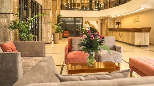 Eine geräumige Lobby mit einer Rezeption, bequemen Sitzgelegenheiten und einem modernen Kronleuchter.
