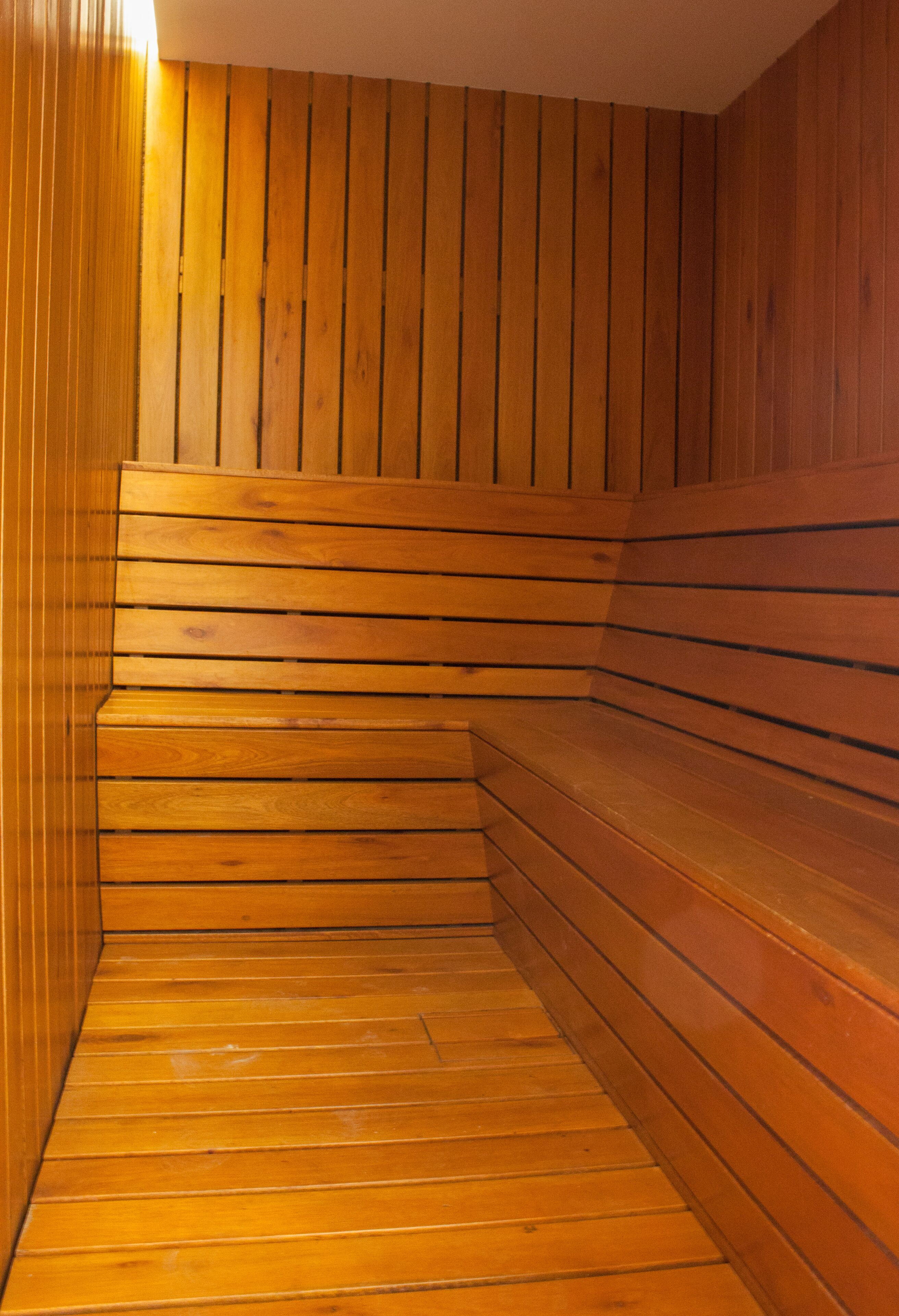 Un sauna avec des bancs et des murs en bois.