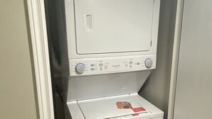 A compact, white laundry room with a built-in washer and dryer.