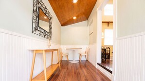 A hallway with wooden flooring, a white wall, a wooden ceiling, and a mirror with a black frame. - BE STILL- 4 Bedroom, 3 Bath with POOL & Guest Cottage (Key West)
