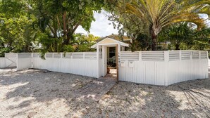 A fenced property with a gravel driveway leading to a gated entrance. - BE STILL- 4 Bedroom, 3 Bath with POOL & Guest Cottage (Key West)