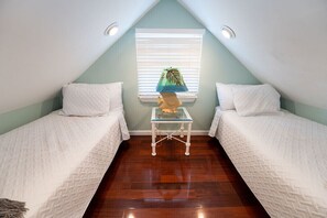 A room with two single beds, a small table with a lamp, and a window with blinds. - BE STILL- 4 Bedroom, 3 Bath with POOL & Guest Cottage (Key West)