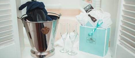 Un angolo con un secchiello per champagne, due bicchieri e una confezione regalo.