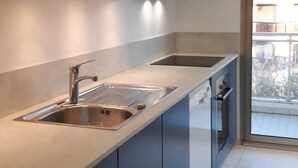 A modern kitchen with a large island, stainless steel appliances, and a view of the outdoors. - Apartment In A Residence With Swimming Pool Wifi (Cannes)
