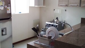 Una cocina moderna con estufa integrada, un lavamanos y un refrigerador.