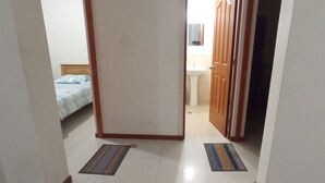 Un pasillo estrecho con una cama y un baño al fondo.