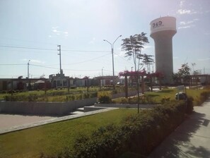 A water tower labeled "D&D" in a landscaped area with pathways, greenery, and buildings in the background. - New House-close to park and 8 min from Oasis Huacachina-ICA (Ica)