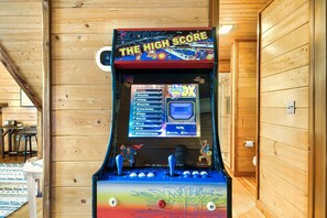 A pinball machine titled "The High Score" in a wooden room.