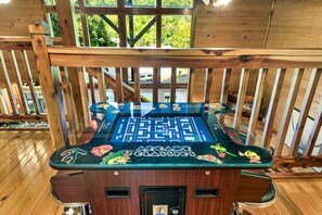 A wooden deck with a vintage arcade game table featuring 'Arcade Classics' and 'Space Invaders' graphics.