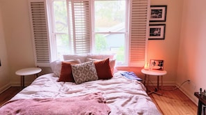 Relax in a cozy bedroom with a large bed, a small table, and a wall-mounted shelf.
