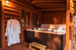 Relax in a cozy cabin-style room with a hot tub and comfortable seating area.