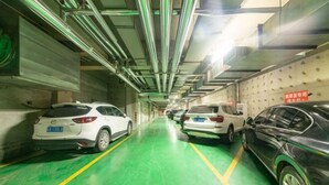 A multi-level parking garage with cars parked on multiple floors. - Lianjia Holiday Hotel (Jigang Senior High School) (Jinan)