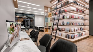 A modern library with a long table, black chairs, and bookshelves. - Ascott Star KLCC Kuala Lumpur (Kuala Lumpur)