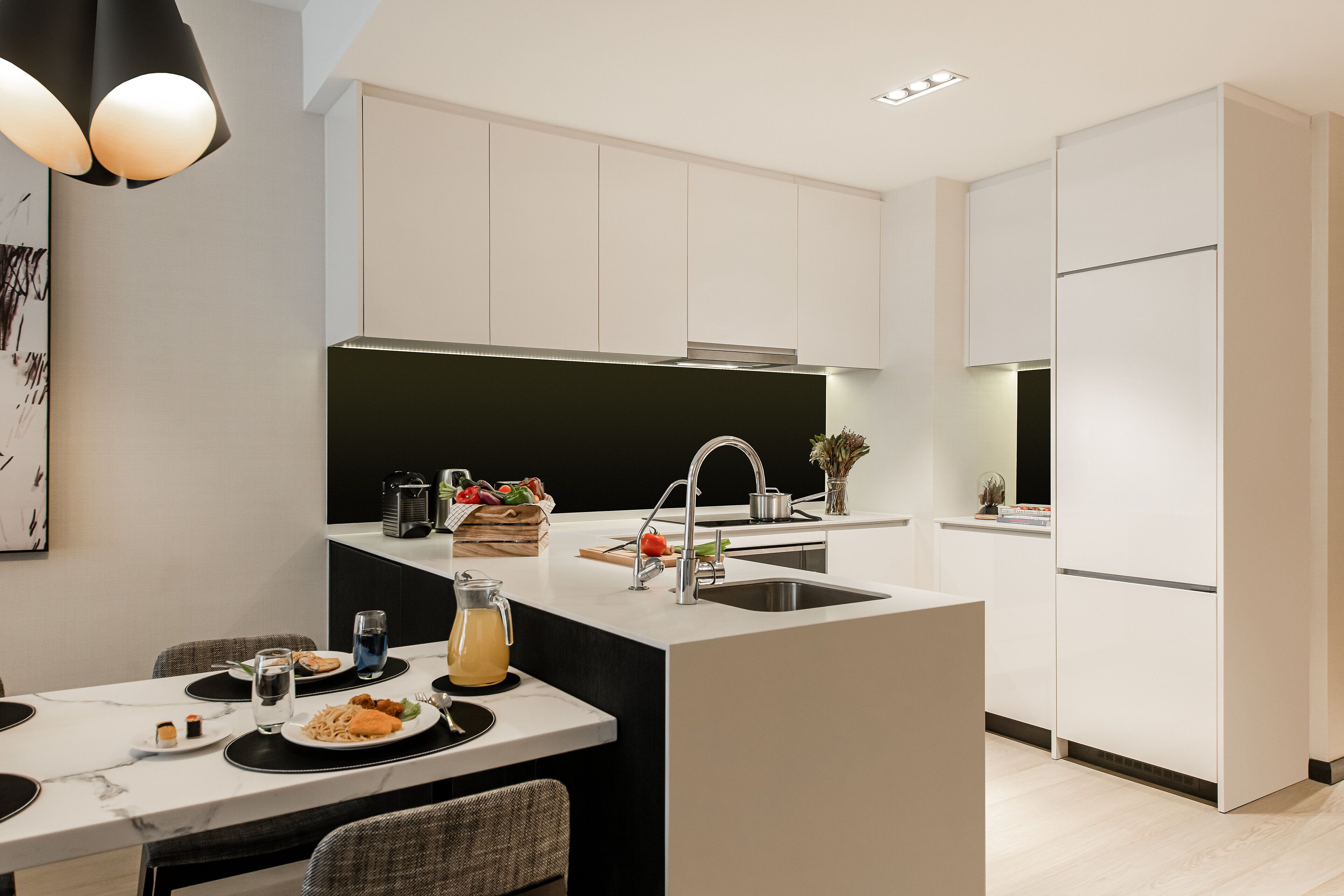 A modern kitchen with a central island, white cabinetry, and a black backsplash.