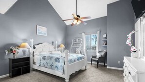 A bedroom with a bed, nightstands, a desk, and a TV. - Rudy's Reel 'Em Inn By Beach Star (Myrtle Beach)