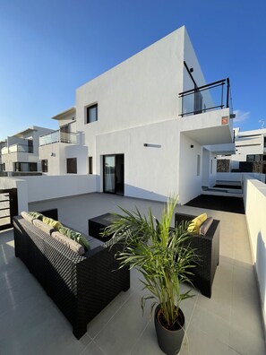 A modern rooftop terrace with outdoor furniture and potted plants. - Mirador del Mar Lanzarote (Costa Teguise)