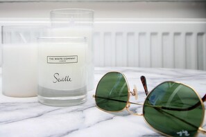 A candle labeled "The White Company London" and a pair of sunglasses on a marble surface. - Eveswell Studios Comfort Studio 10 (Newport)