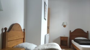 Ein Schlafzimmer mit einem hölzernen Bett, einem Nachttisch, einer Wandlampe und einer Deckenleuchte.