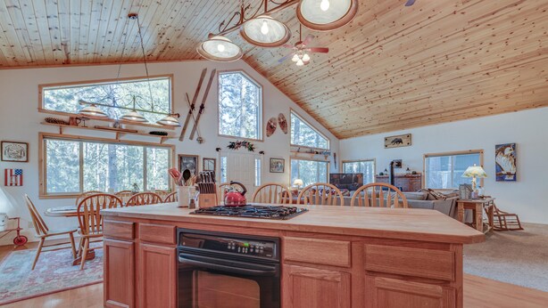 A spacious kitchen with wooden cabinets, a central island, and large windows. - Relax and cozy-in with friends at this spacious Graeagle cabin (Graeagle)