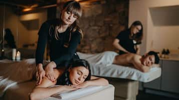 A massage therapy room with two clients receiving treatment.