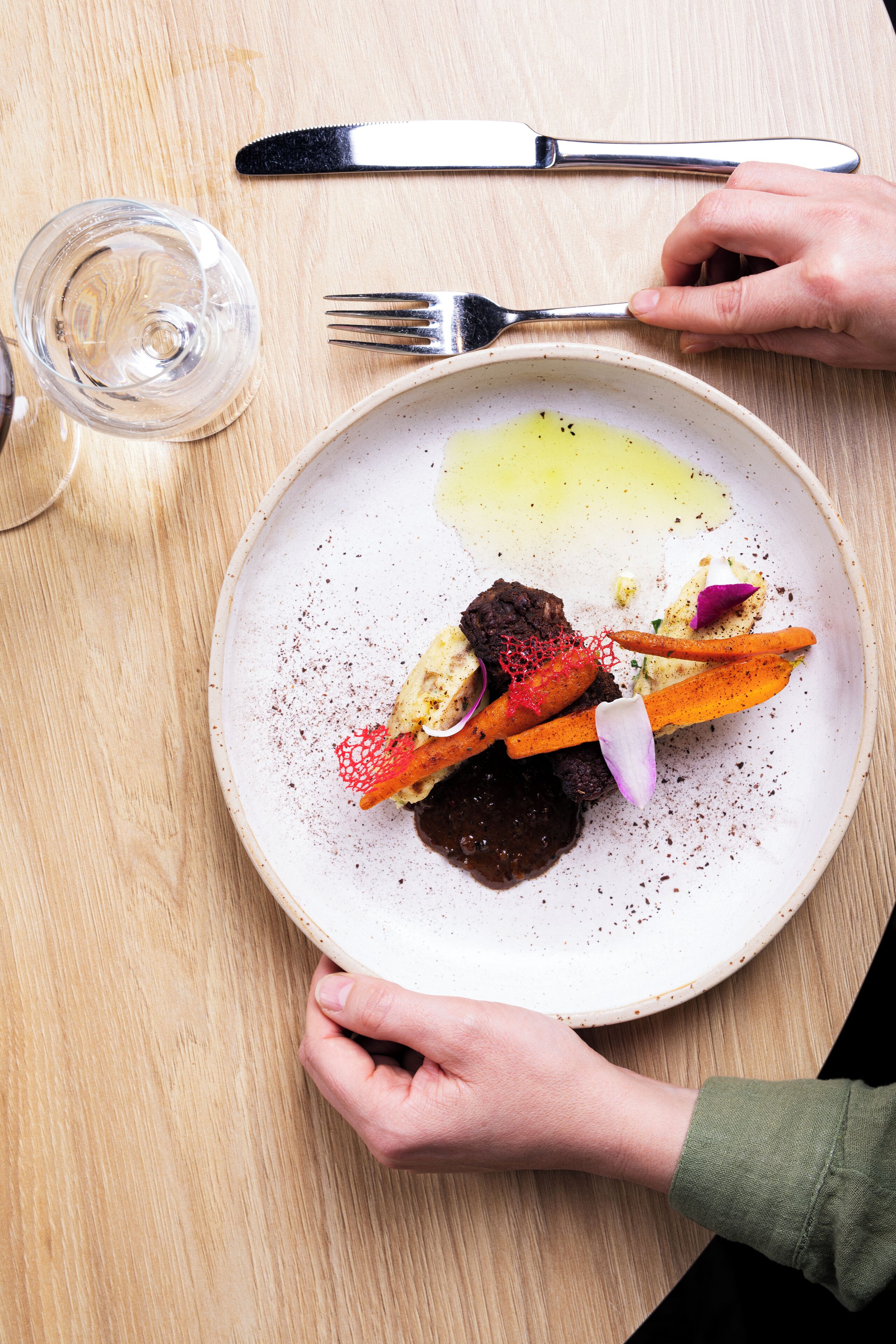 Un plato de comida con un tenedor y un cuchillo sobre una mesa de madera.