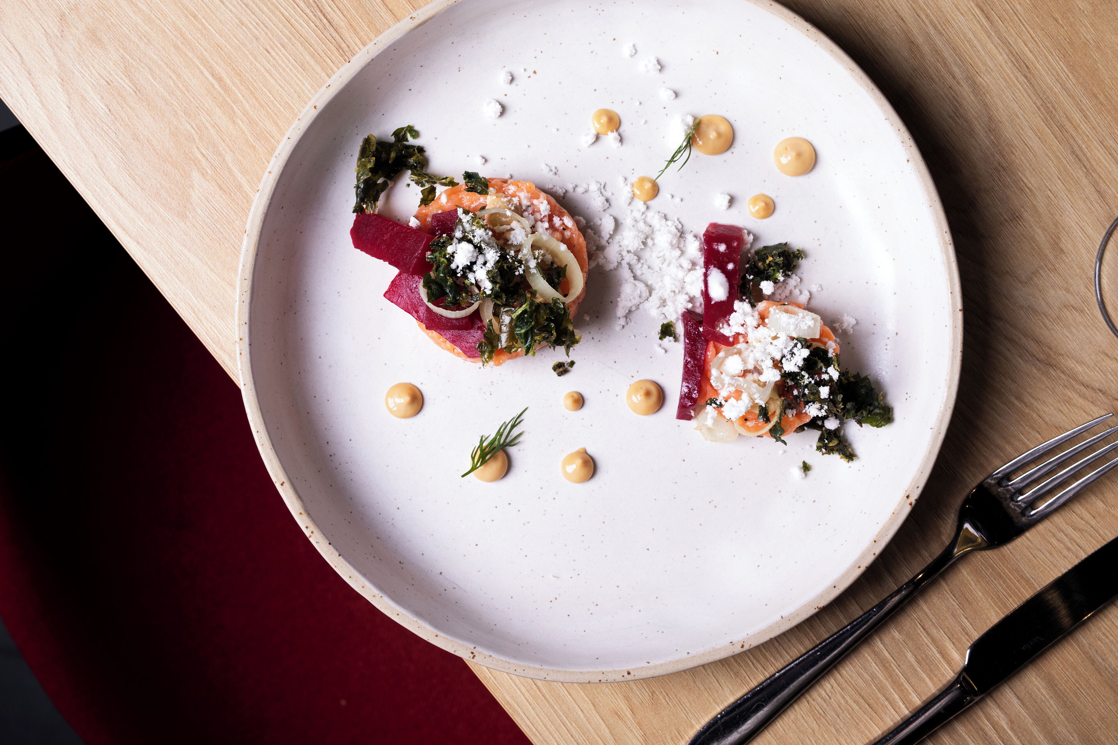 A white plate with a dish on a wooden table.