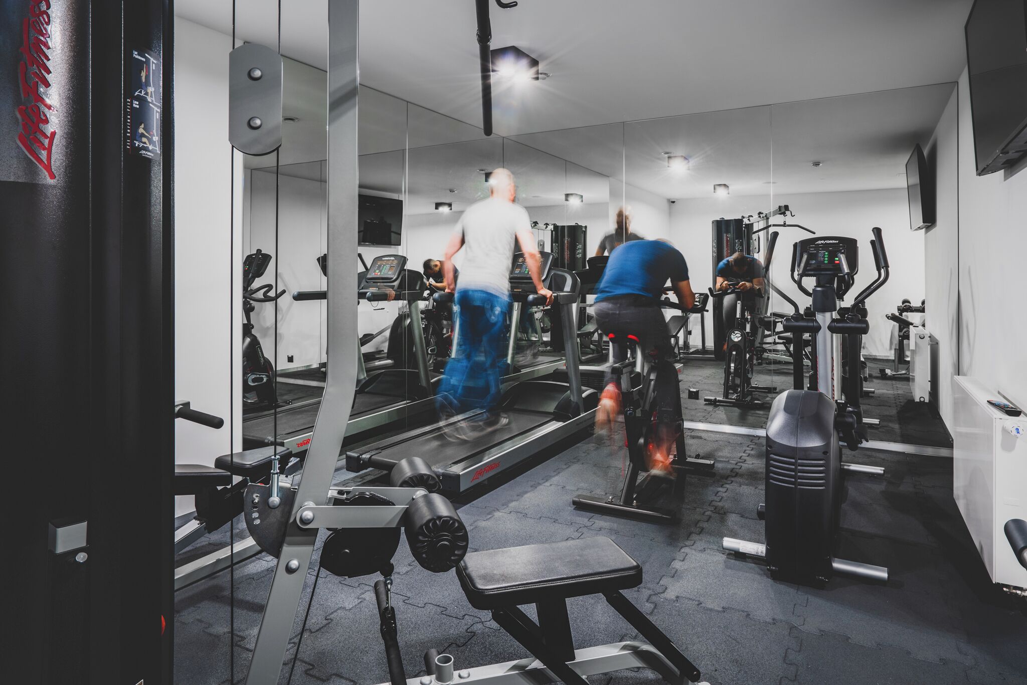 A gym with treadmills, exercise bikes, and weight machines.