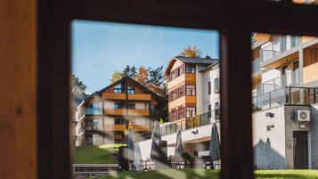 Ein Blick auf ein mehrstöckiges Gebäude mit Balkonen, Sitzgelegenheiten im Freien und einer Rasenfläche.