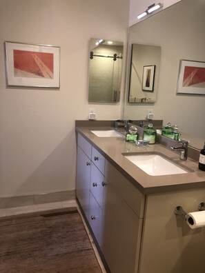Ein Badezimmer mit zwei Waschbecken, einem großen Spiegel und einem Schrank mit Schubladen.