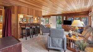 Un intérieur en bois avec un espace bar, des sièges et un téléviseur.