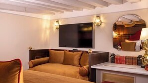 Une chambre d’hôtel équipée d’un lit, d’un téléviseur à écran plat, d’une table de chevet et d’un miroir.